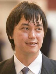 Asian man wearing tie glancing off-camera
