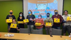 People facing camera holding boxes